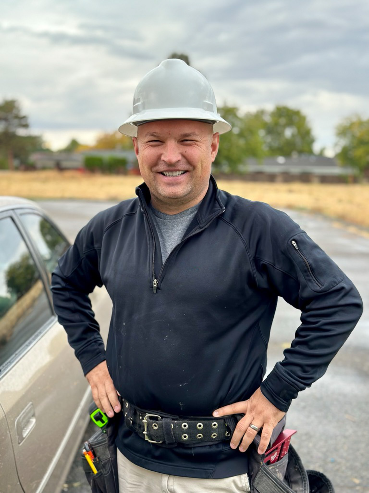 Headshot of a Trident Home Solutions contractor standing on-site in a white hard hat